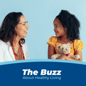 A doctor and a girl holding a stuffed bear