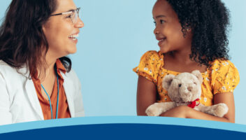 A doctor and a girl holding a stuffed bear