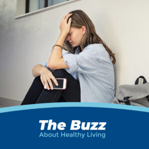 A girl sitting against the wall, appearing very upset