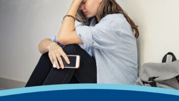 A girl sitting against the wall, appearing very upstet