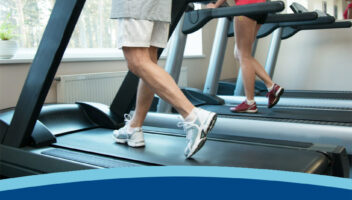 Two people walking on treadmills